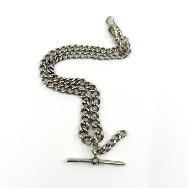 Antique sterling silver Albert chain with double dog clips and T-bar, shown laid out on a white background.