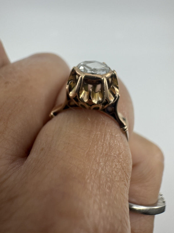 Close-up of the antique rose gold ring worn on the finger, showing the rose-cut diamond and decorative setting.
