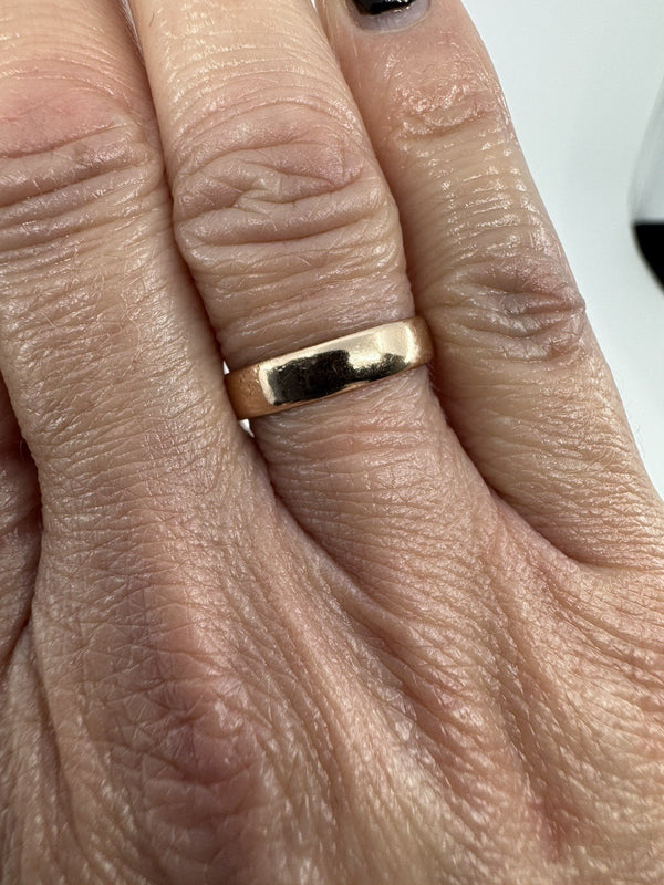 Hand shot showing fit and width of a Victorian 9ct rose gold full band ring.