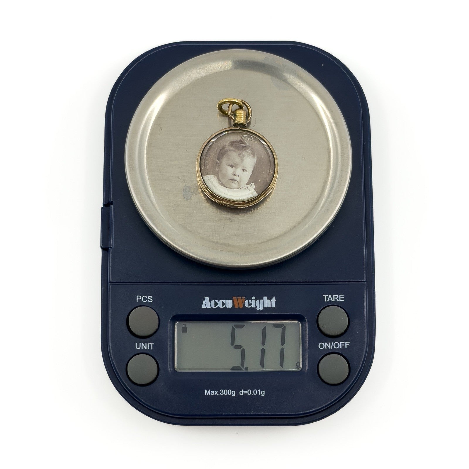 Antique rolled gold double sided glass photo locket shown on scales weighing approximately 5.1g