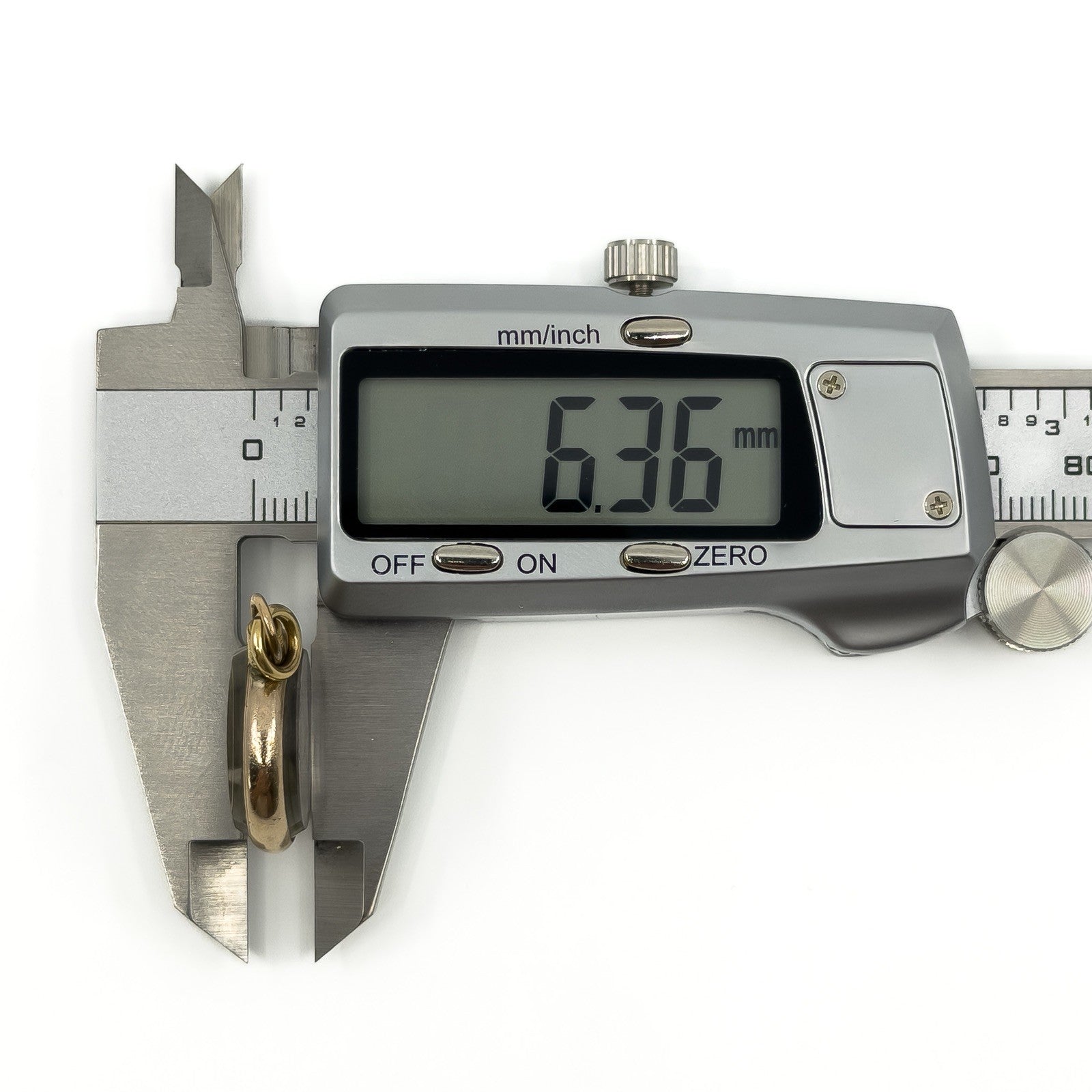 Side measurement of antique rolled gold double sided glass photo locket showing approximately 6.3mm depth