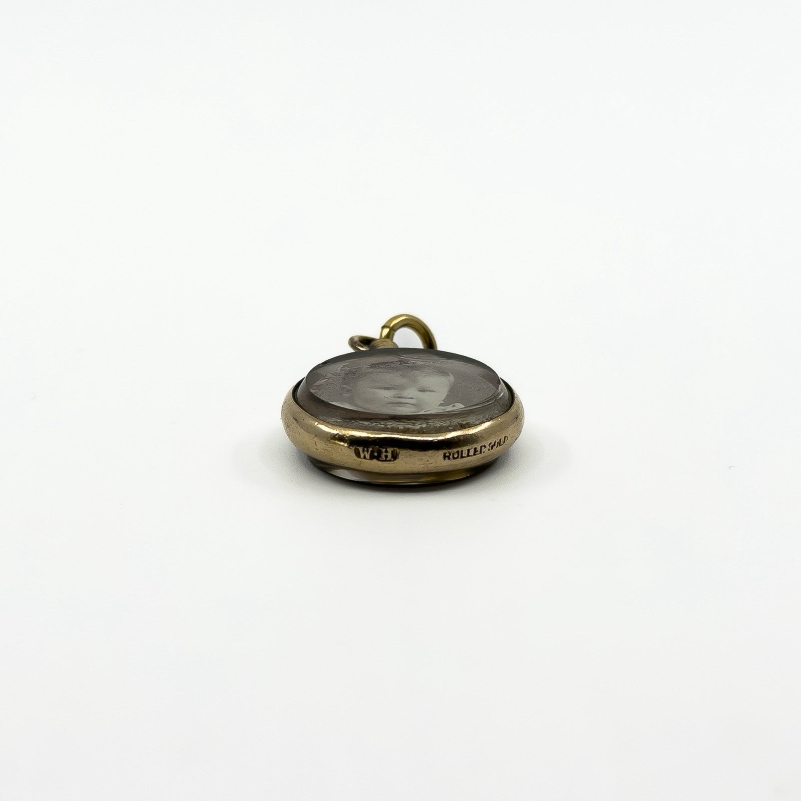 Antique rolled gold double sided photo locket with edge stamp and original portrait visible through glass
