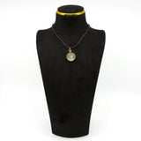 Antique rolled gold glass photo locket shown on a black display stand as a pendant