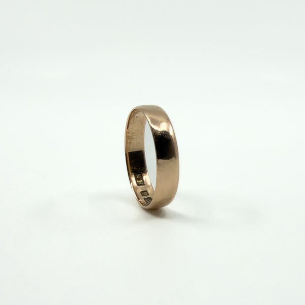 Low profile view of a Victorian rose gold full band ring against a white background.