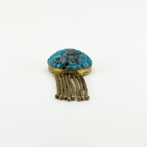 Low front view of Victorian 18ct gold locket showing the turquoise-set dome and articulated gold tassels.
