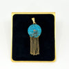 Front view of Victorian 18ct gold turquoise and rose-cut diamond tassel locket on a black display pad.