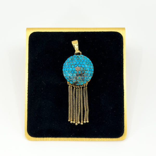 Front view of Victorian 18ct gold turquoise and rose-cut diamond tassel locket on a black display pad.