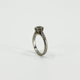 Upright side view of antique platinum old-cut diamond solitaire ring with raised claw setting
