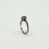 Upright side view of antique platinum old-cut diamond solitaire ring with raised claw setting
