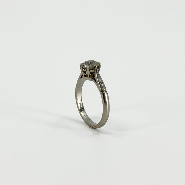 Upright side view of antique platinum old-cut diamond solitaire ring with raised claw setting