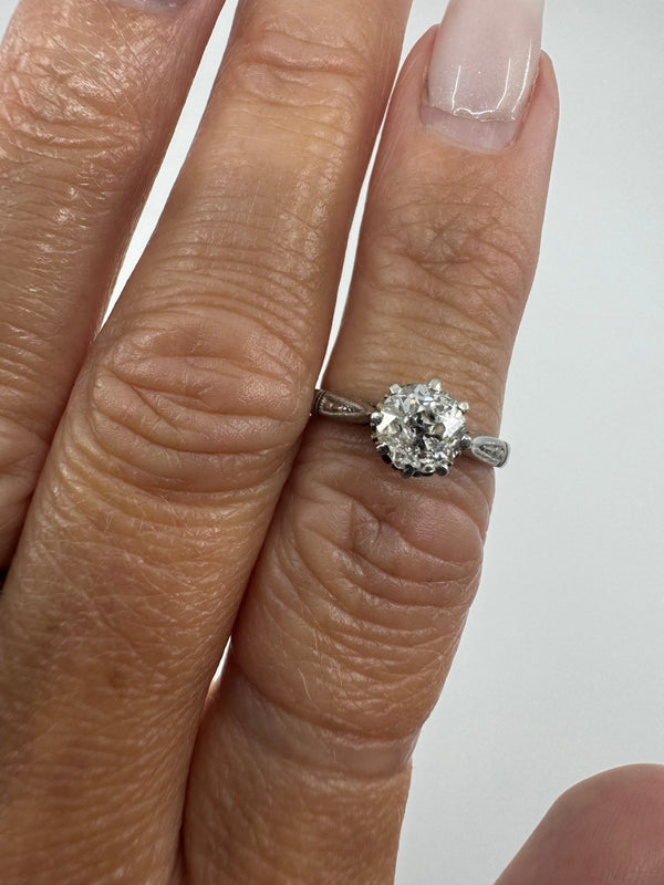 Antique platinum old-cut diamond solitaire ring worn on the finger, showing the eight-claw setting