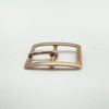 Low angle shot showing curve and depth of antique gold buckle charm