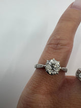 Antique platinum old-cut diamond solitaire ring worn on the finger with engraved shoulders visible