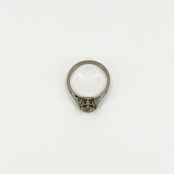Top view of antique platinum diamond solitaire ring showing open gallery and engraved shoulders