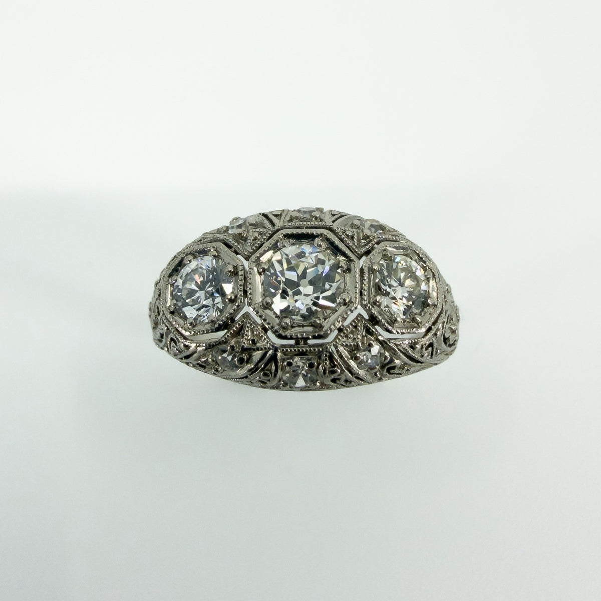Close front view of Art Deco platinum diamond trilogy ring with filigree openwork