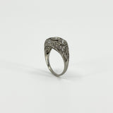 Angled view of Art Deco platinum diamond trilogy ring showing pierced filigree shoulders