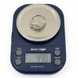 Art Deco platinum diamond trilogy ring shown on scales weighing approximately 4.90g
