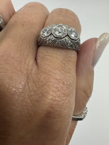 Close up of Art Deco platinum diamond trilogy ring worn on the hand
