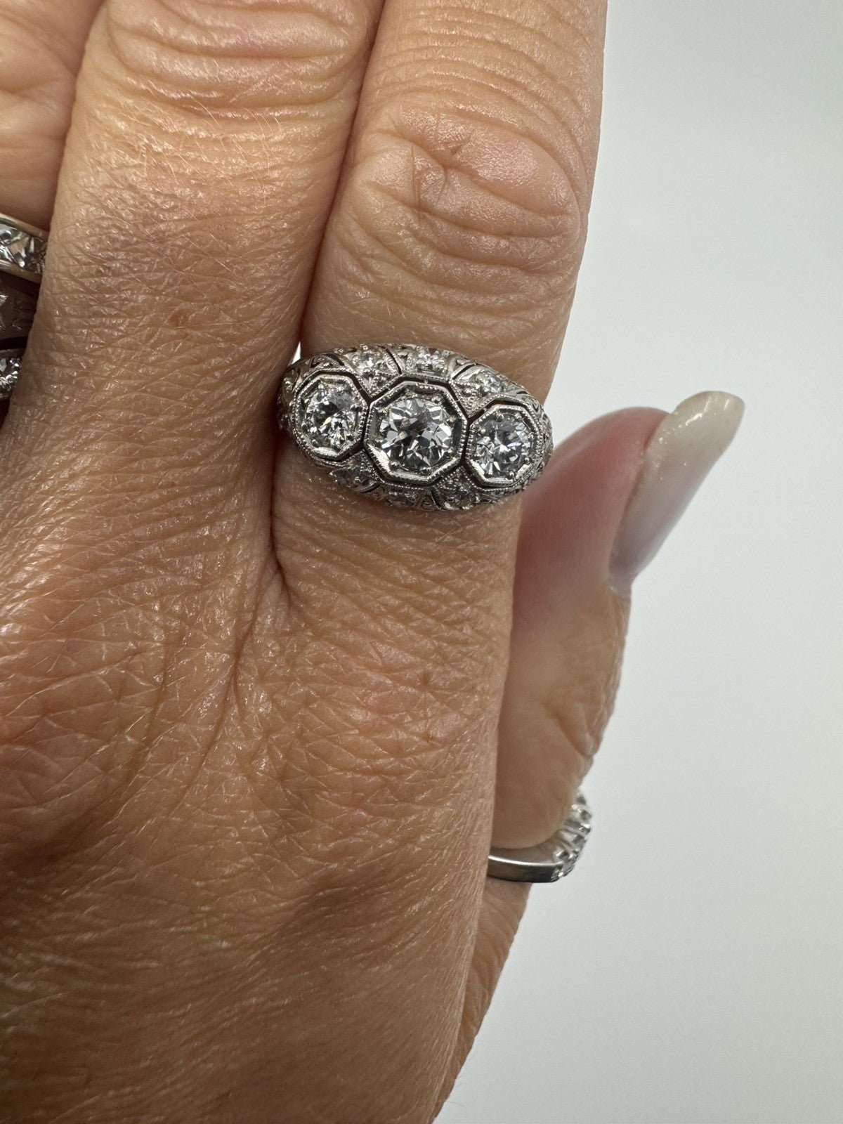 Art Deco platinum diamond trilogy ring worn on the hand showing its front profile