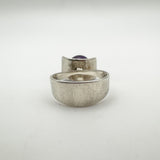 Back view of modernist ring showing thick silver band and amethyst setting