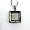 Rear view of the sterling silver pendant with visible 925 stamp and open back behind the mother of pearl.