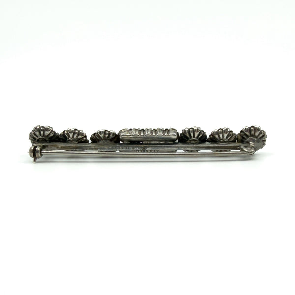 Back of sterling silver paste and pearl bar brooch showing pin and rolling C clasp fitting.