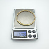 Vintage 9ct gold emerald bangle on scale weighing 12.08g