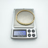 Vintage 9ct gold emerald bangle on scale weighing 12.08g