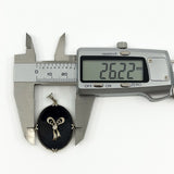 Digital caliper measuring the black onyx and diamond bow pendant width at approximately 26.22mm.