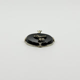 Low back view of black onyx bow pendant showing the oval reverse, white gold frame and bail.
