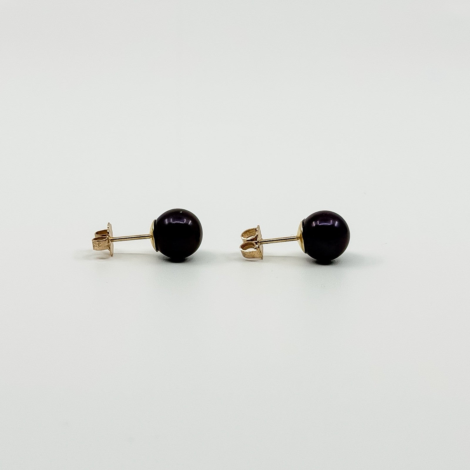 Side view of 9ct gold cultured black pearl stud earrings with posts and butterfly backs