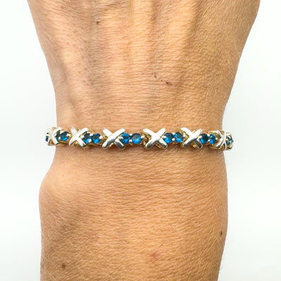 Blue CZ tennis bracelet with X links worn on wrist