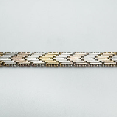 Close-up of flat plaited chain links in rose, yellow and silver tone