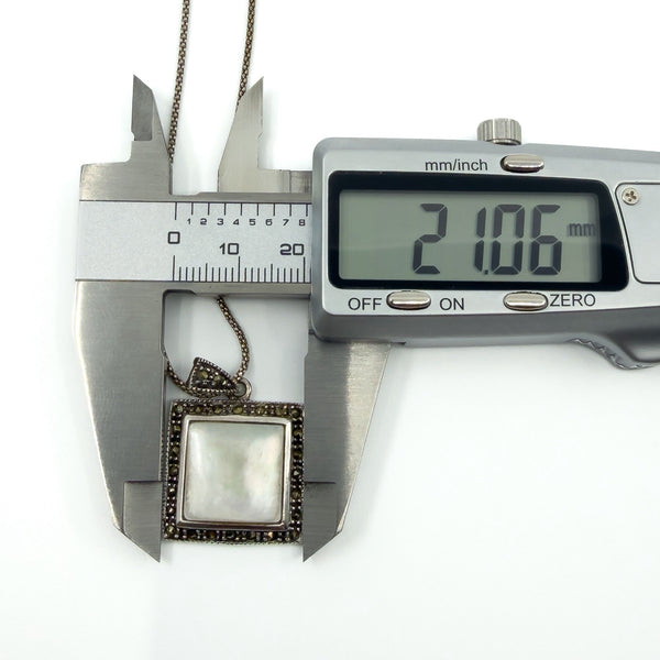 Caliper photo showing pendant width at 21.06mm across the square setting.