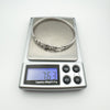 Sterling silver bangle on digital scale showing weight as 7.63 grams