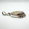 Side angle showing silver bead detailing and oval agate stone with polished finish