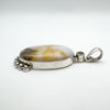 Side view showing domed agate stone and silver bezel setting with peridot accent