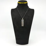 Vintage sterling silver ingot pendant shown on a black display bust