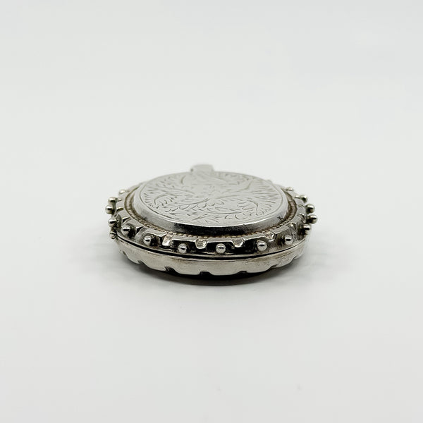 Low side view of the chunky sterling silver oval locket showing the beaded border detail