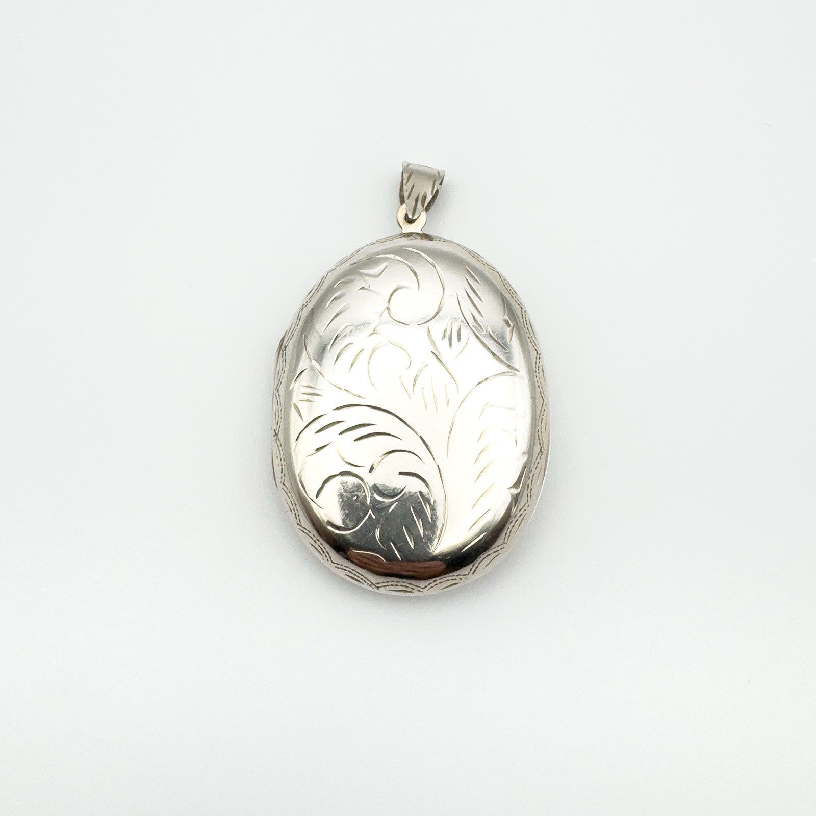 Large sterling silver locket with foliate engraving