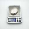 Large vintage sterling silver oval locket on digital scale showing weight of 16.92 grams.