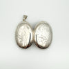 Both sides of silver oval locket with scrollwork design