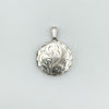 Close-up of round silver locket with etched floral design and scalloped edge