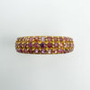 Three-row ruby pavé band showing natural colour variation and gold overlay