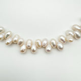 Close-up of white baroque pearls on sterling silver bracelet