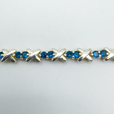 Detail of prong set blue CZs and X-shaped silver links