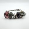 Close-up of 5 unique charms on Trollbeads silver foxtail bracelet