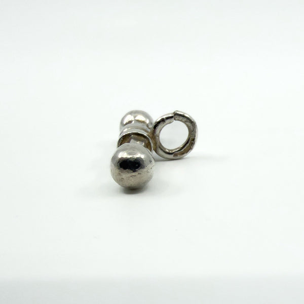 End-on view of the sterling silver T-bar charm showing the rounded terminal and bail loop.