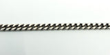 Close-up of the flat link curb chain in sterling silver, showing the polished, low-profile link pattern.