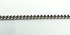 Close-up of the flat link curb chain in sterling silver, showing the polished, low-profile link pattern.